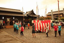 神社で盆踊りをする人たちの写真