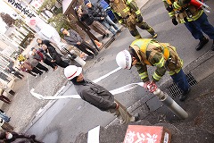 消火栓使用の指導を受ける住民の写真 消火栓使用の指導を受ける住民の写真