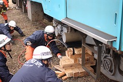 枕木と油圧ポンプで車両を持ち上げる訓練の写真