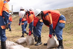 積み土のう工を行う女性消防団のようす