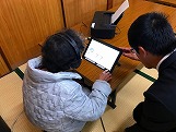 タブレットを見る高齢者の写真