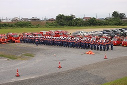 グラウンドに整列する水防団の写真