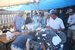 日陰で飲み物を配布する写真 日陰で飲み物を配布する写真