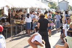 汗を拭いながら露店を回る市民の写真